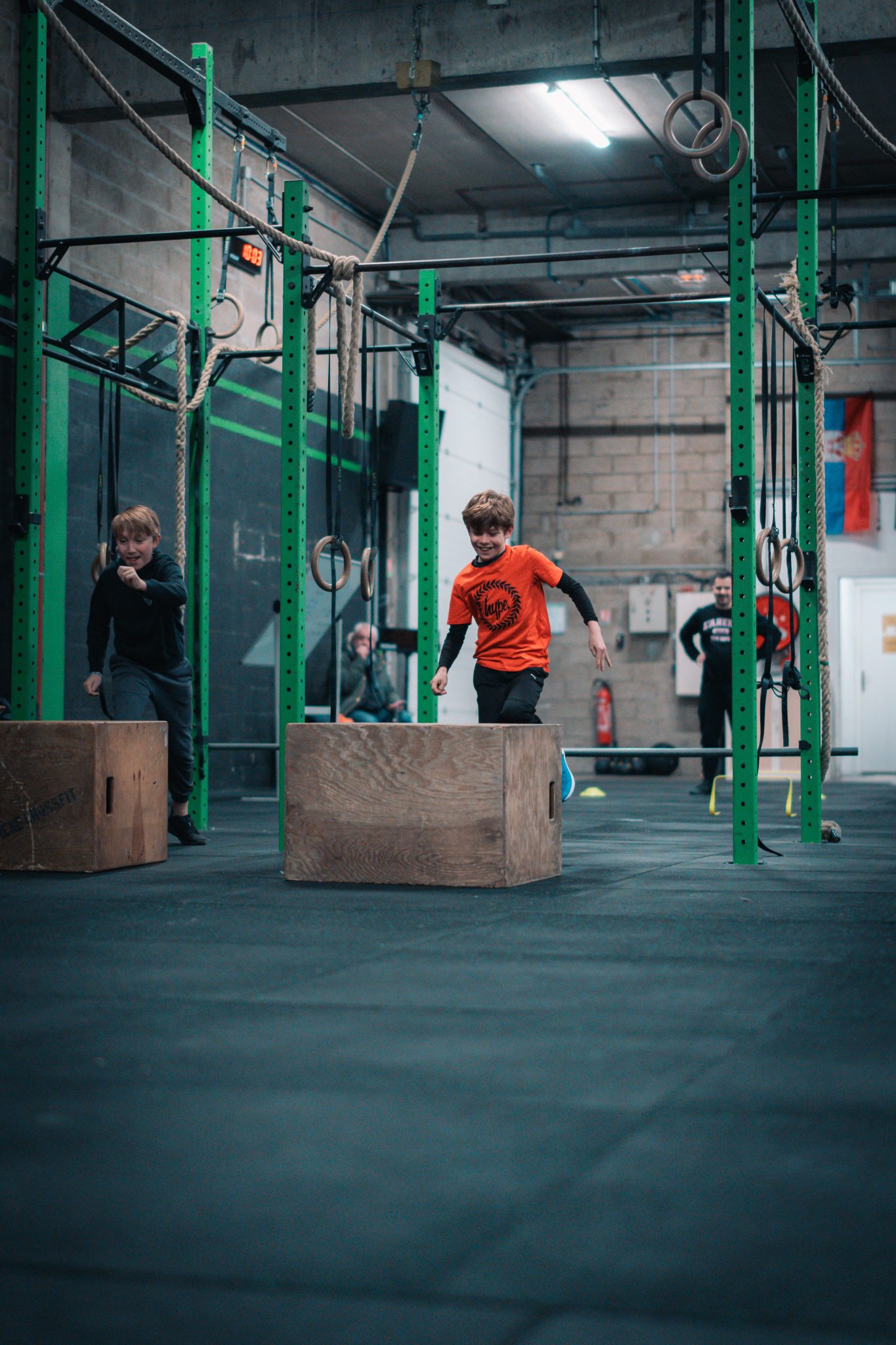 Un coach et une enfant à l’entraînement avec des kettlebells