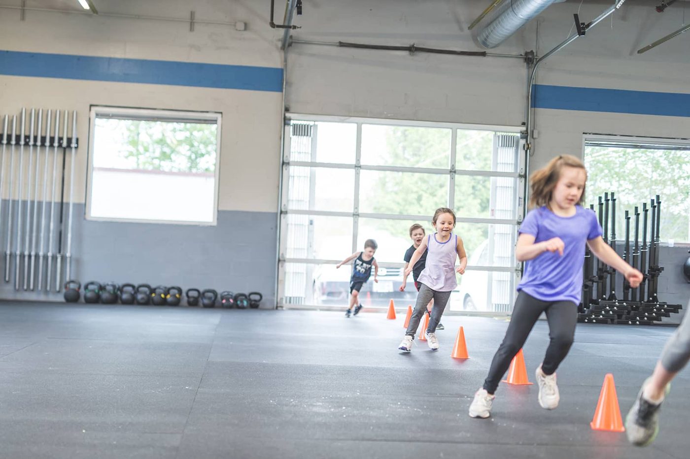 Des enfants font un exercice de course entre des plots