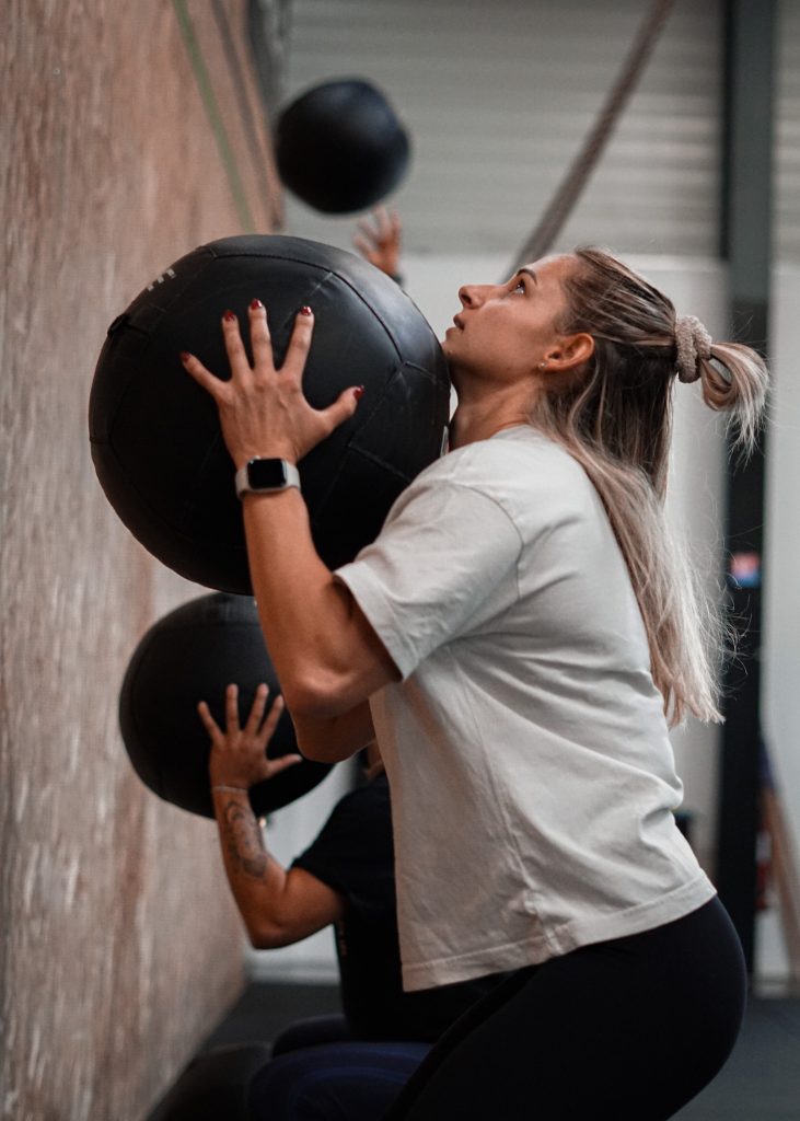 Une athlète au wall ball pendant un WOD à L’Arène Gradignan